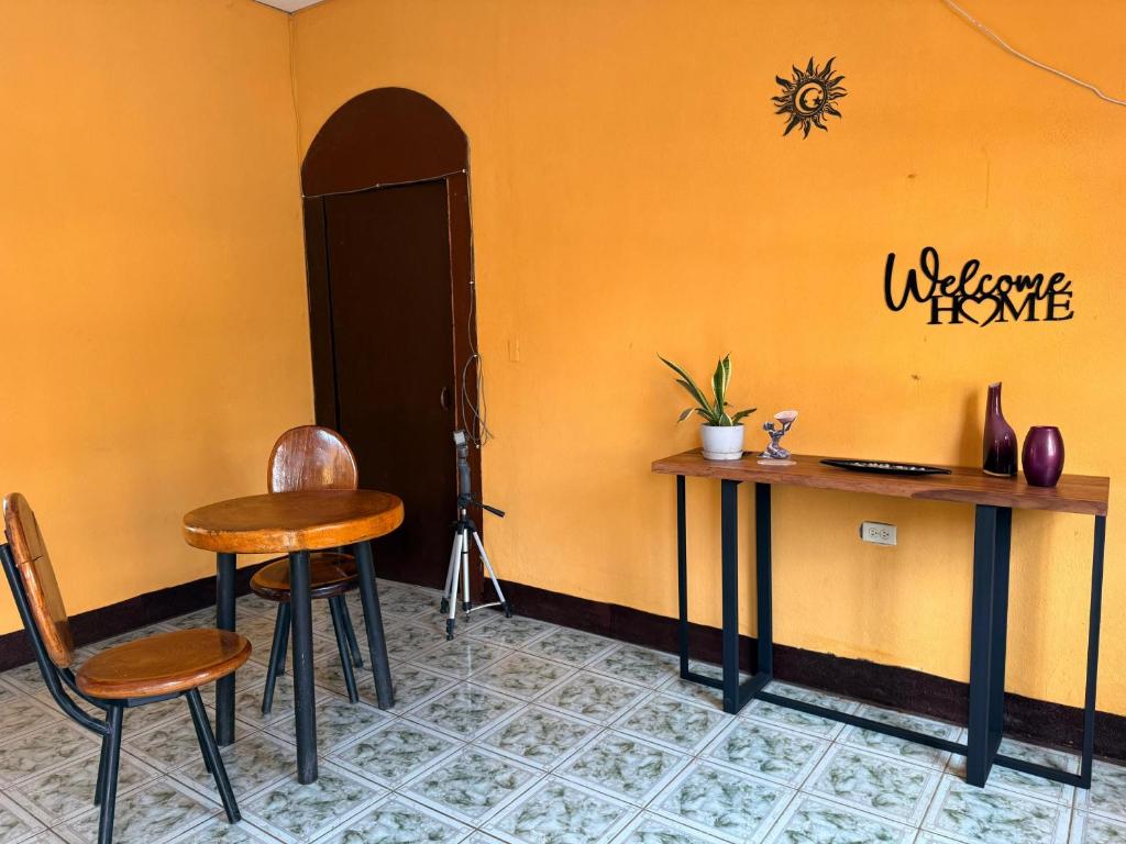 two tables and chairs in a room with a yellow wall at Buena Onda House in Granada