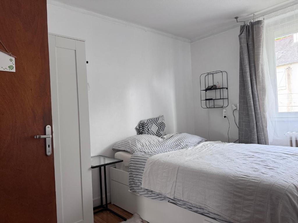 une chambre blanche avec un lit et une fenêtre dans l'établissement Villa Auguste chambre lumineuse, à Quimper