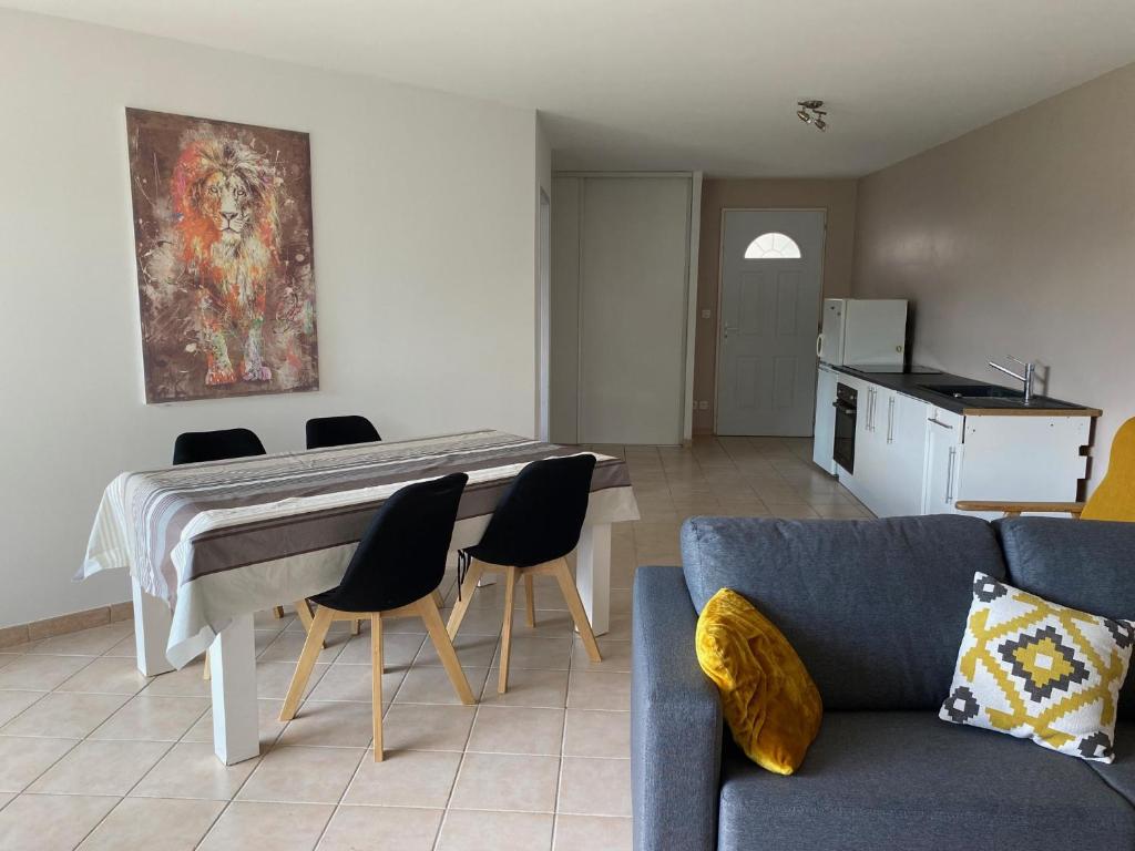 un soggiorno con un divano, un tavolo e delle sedie di Dépendance paisible a Ventenac-Cabardès
