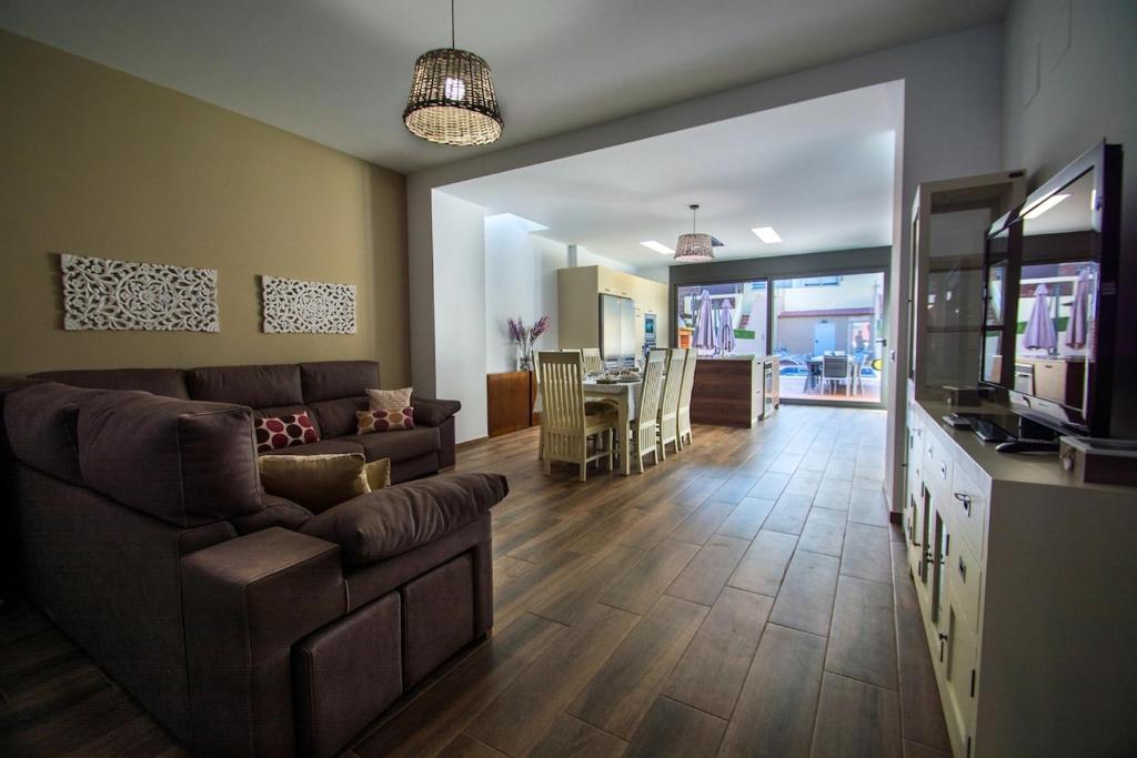 ein Wohnzimmer mit Sofa und Fernseher in der Unterkunft Casa grande con piscina en el centro de Calella, Tramuntana in Calella