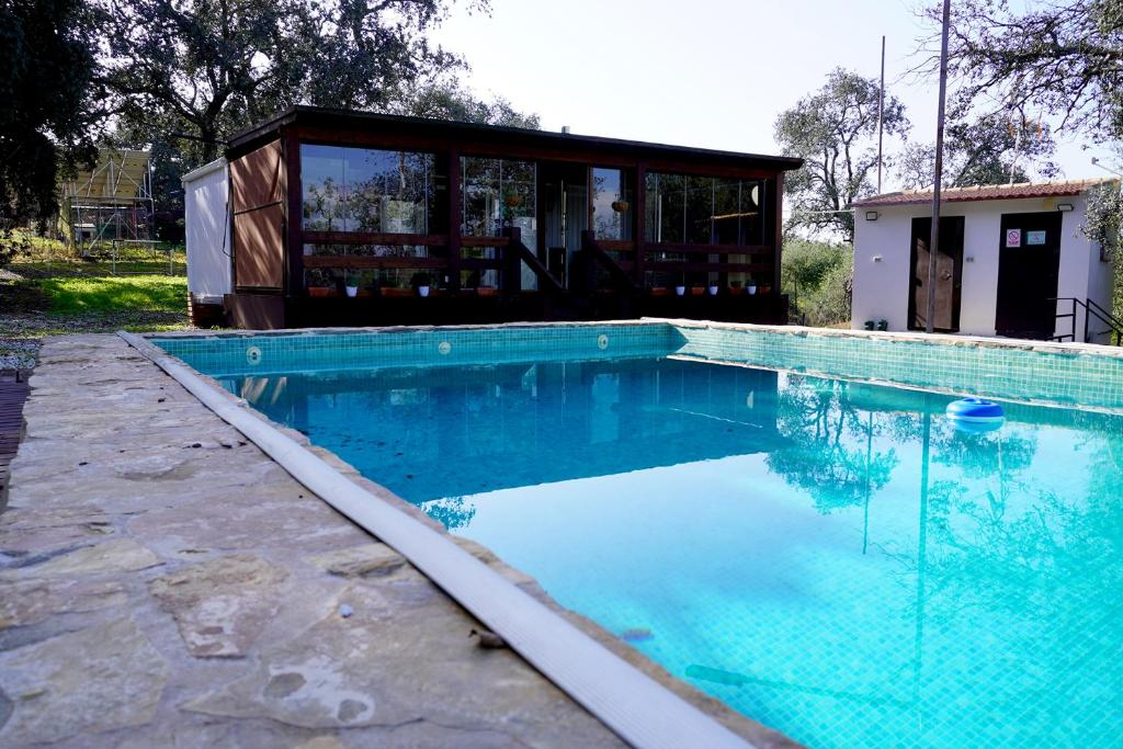 a swimming pool in front of a house at Casa Mobil-Home in La Puebla de los Infantes