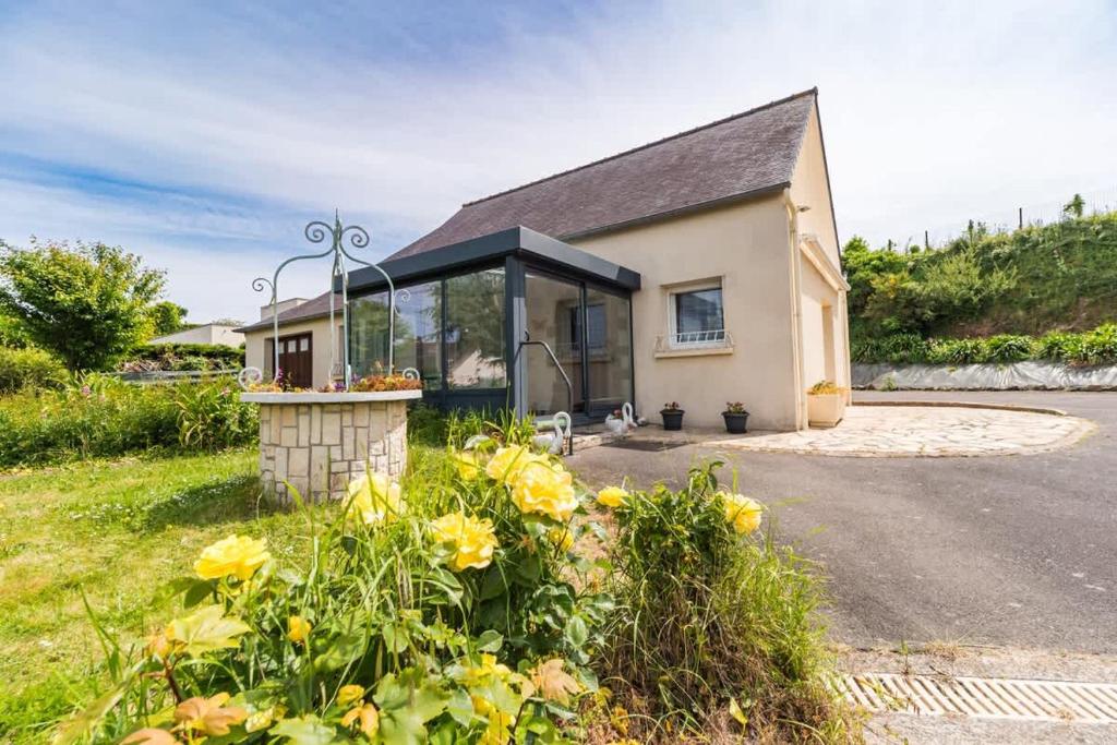 een klein huis met een glazen uitbouw aan een weg bij Maison familiale proche mer - Etables-sur-Mer in Binic