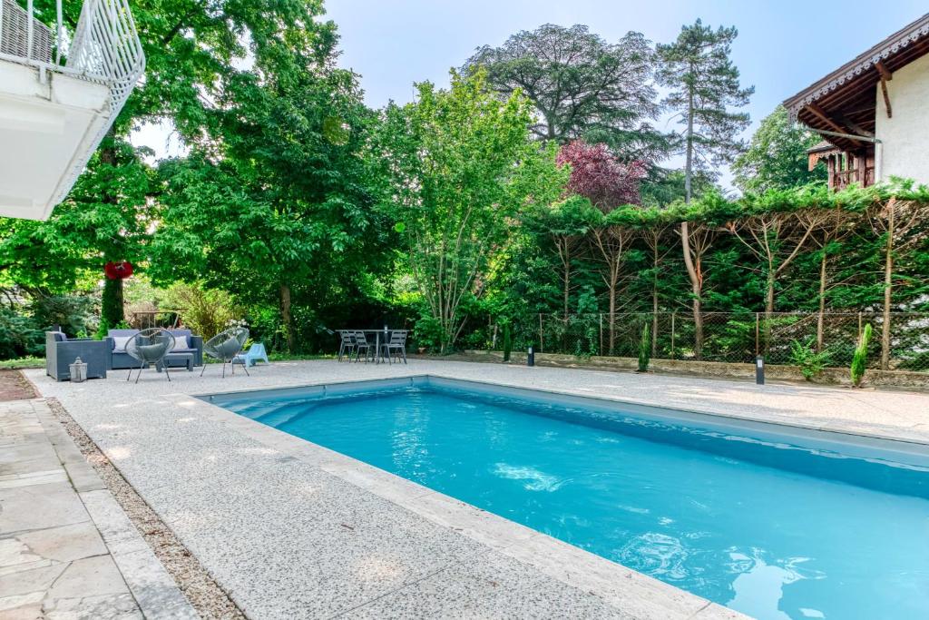 une piscine dans l'arrière-cour d'une maison dans l'établissement Villa Les sabines - Welkeys, à Écully