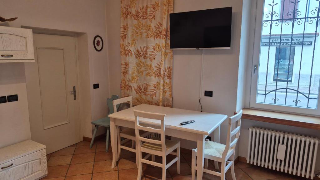 a dining room with a table and chairs and a tv at Casa vacanza Auronzo in Auronzo di Cadore
