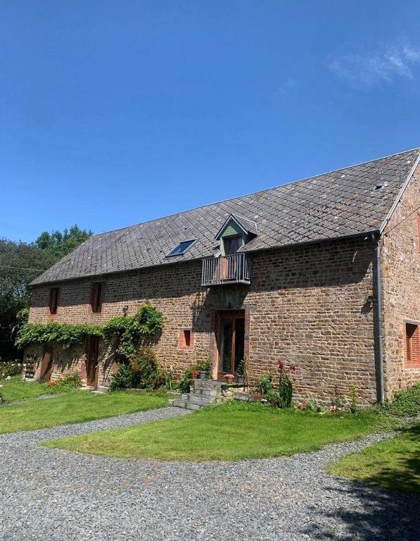 - un ancien bâtiment en briques avec un balcon dans l'établissement Les Rouges Terres Gites - La Laterie, à Saint-Amand