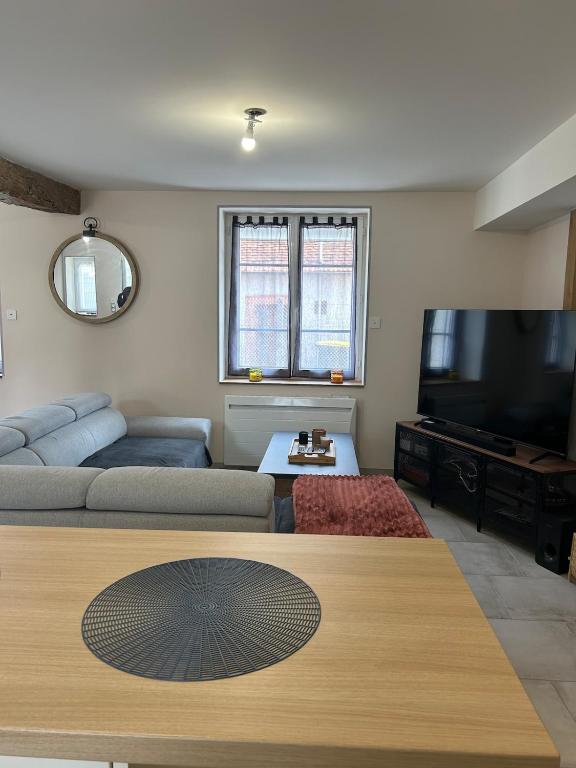 un salon avec un canapé et une télévision à écran plat dans l'établissement Maison avec cour, à Villefranche-Sur-Cher