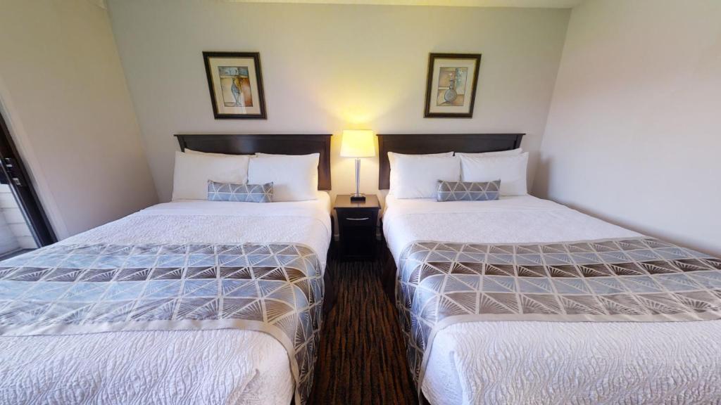 Un pat sau paturi într-o cameră la Recreation Inn and Suites Kelowna