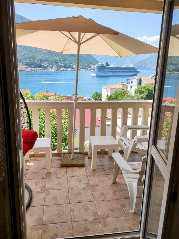 a balcony with a table and chairs and an umbrella at Apartment Bay View in Kotor