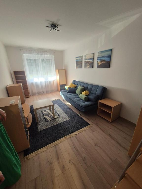 a living room with a blue couch and a table at Sandline in Kecskemét