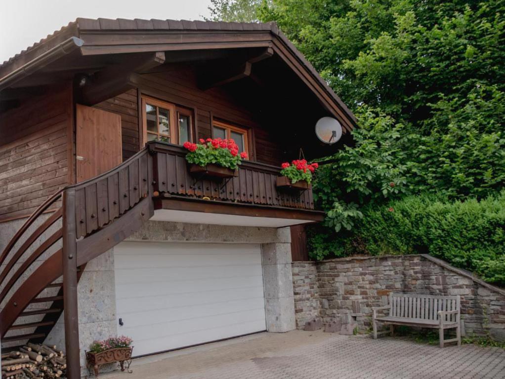 ein kleines Haus mit einem Balkon und einer Garage in der Unterkunft Erika´s Häuschen in Kitzbühel
