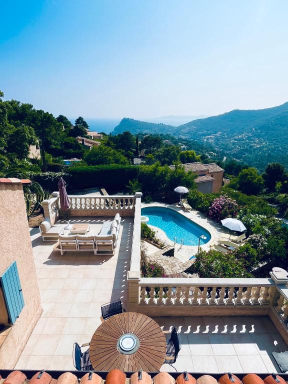 - une vue sur la piscine dotée de chaises et d'un parasol dans l'établissement Stunning Villa with Pool, Sea View & Petanque in Golfe Saint Tropez, à Rayol-Canadel-sur-Mer