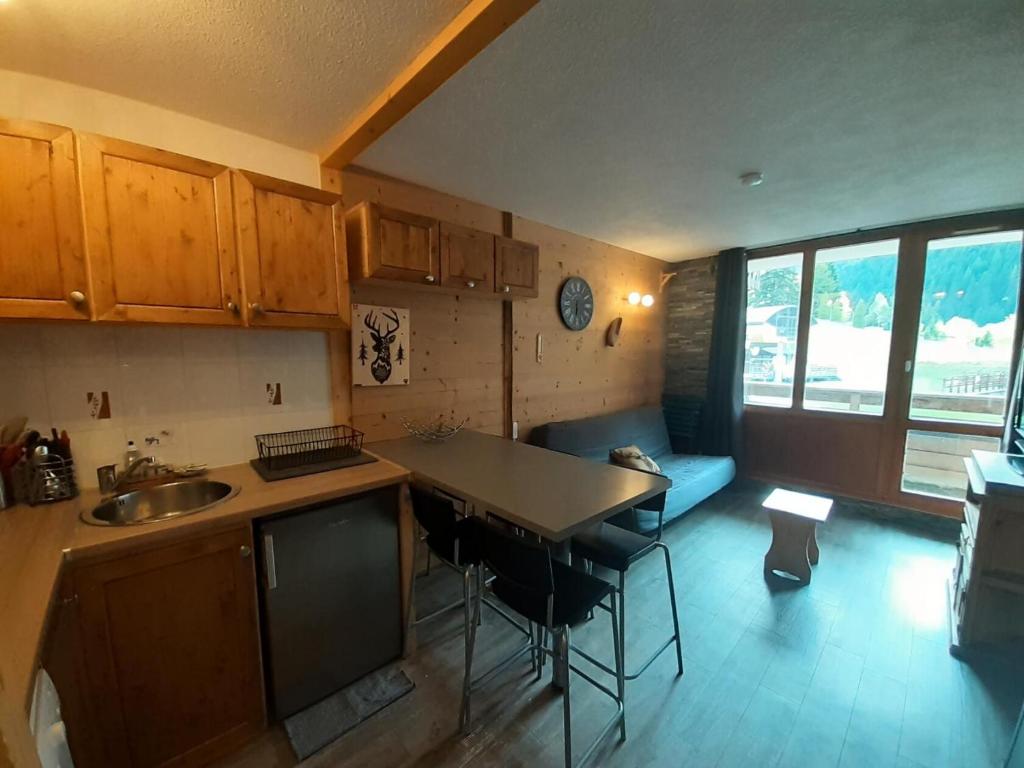 une cuisine avec un évier et une table avec des chaises dans l'établissement Résidence Thabor A - Studio pour 4 Personnes MAE-3573, à Modane