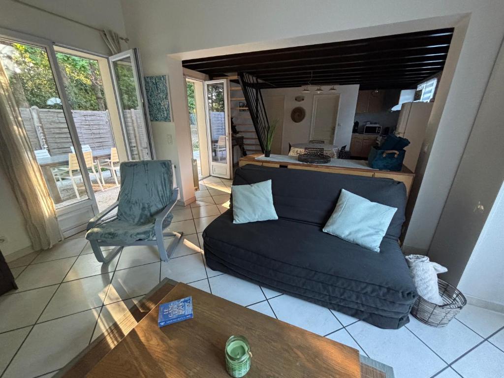 un salon avec un canapé et une table dans l'établissement GuestHouse avec terrasse & jacuzzi- La Teste de Buch, à La Teste-de-Buch