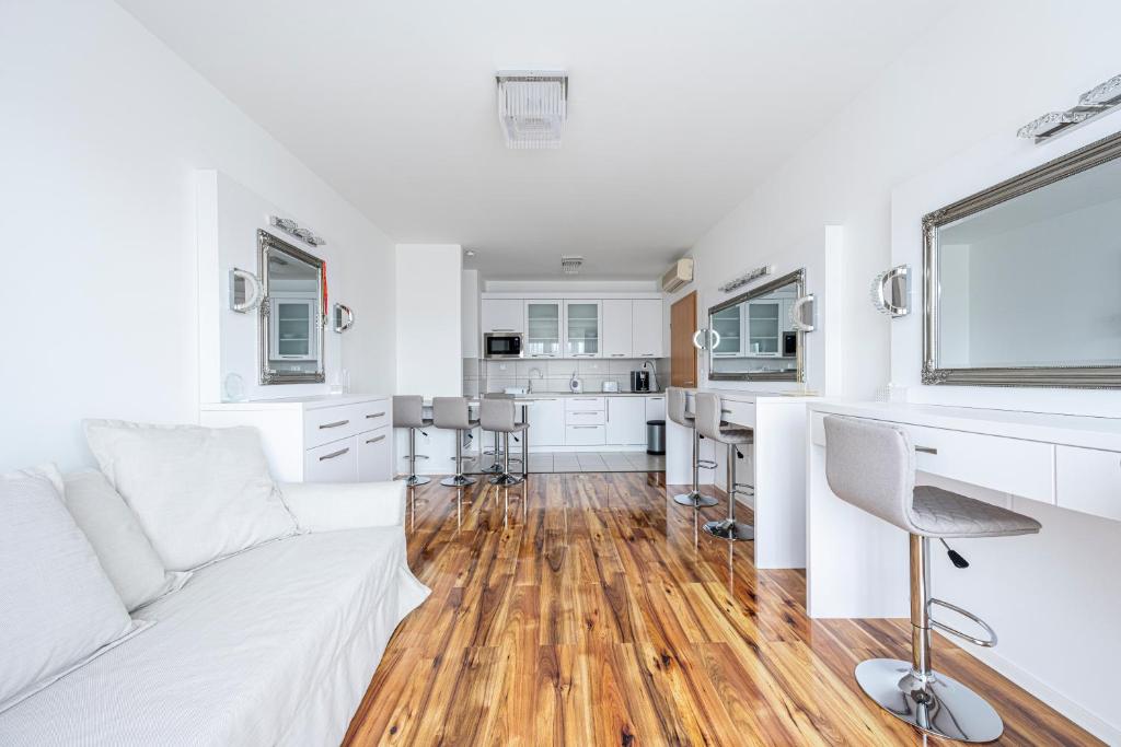 a white living room with a white couch and a desk at TP Spacious Stylish Free parking in Szeged