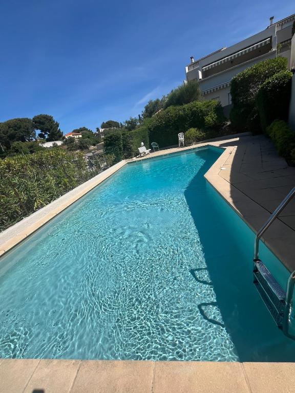 une grande piscine avec de l'eau bleue dans l'établissement T2 avec terrasse et accès piscine, à Cassis