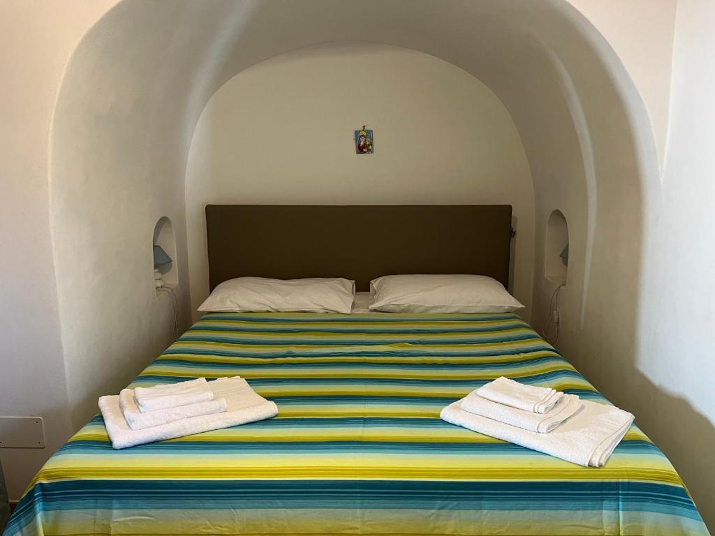a bedroom with a bed with towels on it at Residence Dammusi Riah in Pantelleria