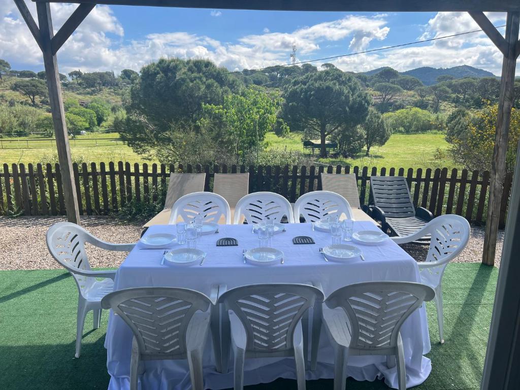 une table avec des chaises blanches et un chiffon de table bleu dans l'établissement Mobil home familial, au Muy