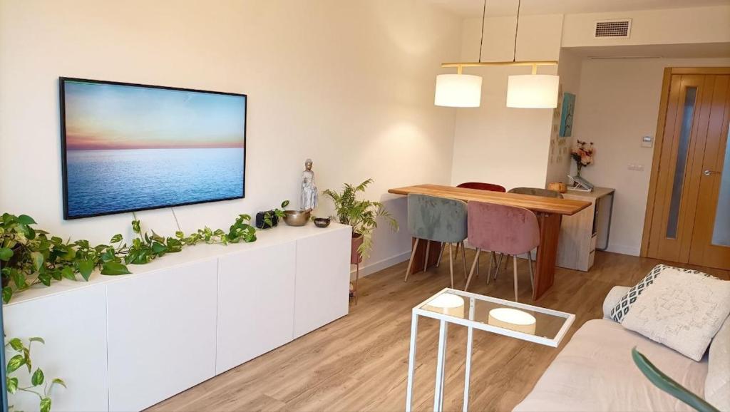 Una sala de estar con un televisor de pantalla plana en una pared. en Ático Premium con Azotea, Pádel y Piscina, en Sant Jordi (San Jorge)