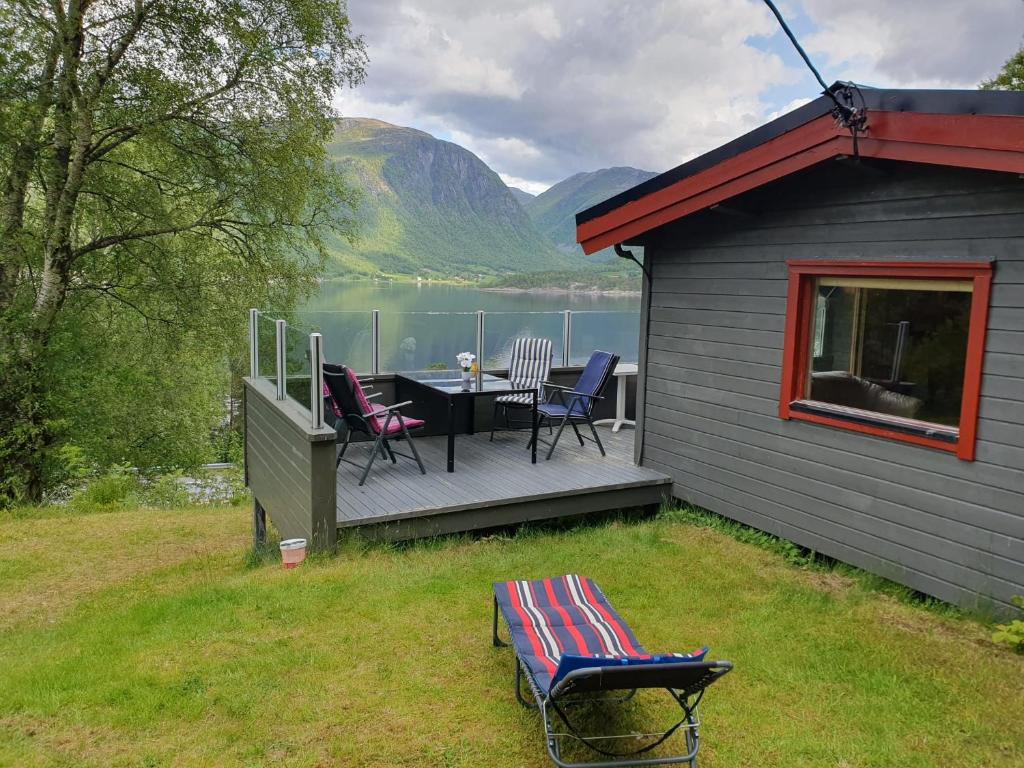 a house with a deck with a table and chairs at Feriehytte Rodal in Rodal