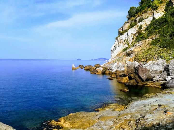 a large body of water next to a rocky shore at La Casa nel Carobio in Ameglia