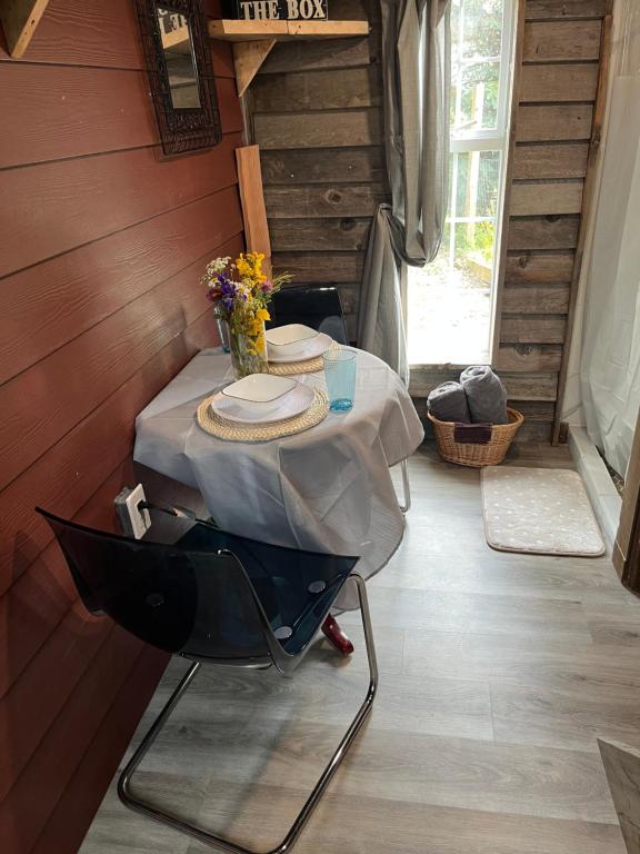 a table with plates and a vase of flowers on it at Rustic Guesthouse in Sayward