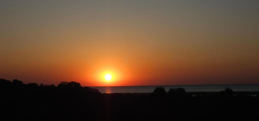 una puesta de sol sobre el océano con la puesta de sol en ROCA Seaview Apartments, en 23 August