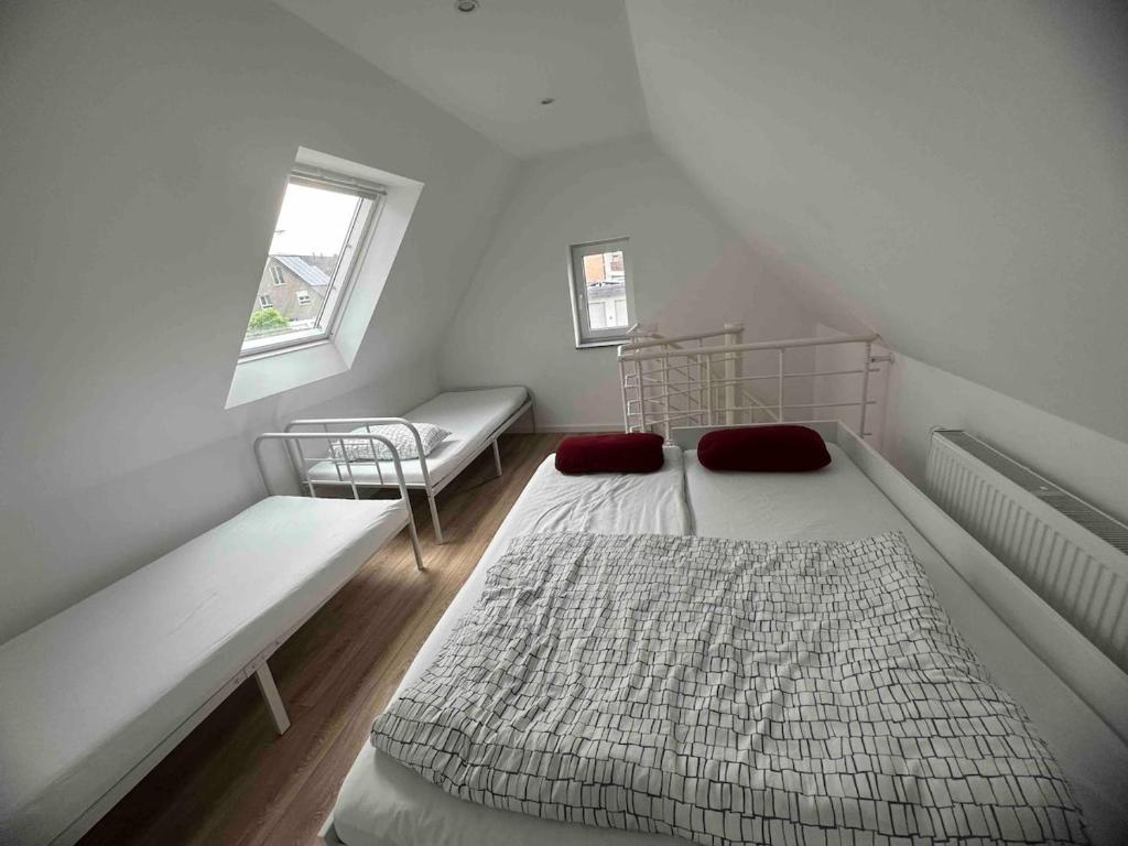 a small bedroom with two beds and a window at Charmantes 2-Etagen Häuschen- Köln-Phantasialand in Hürth