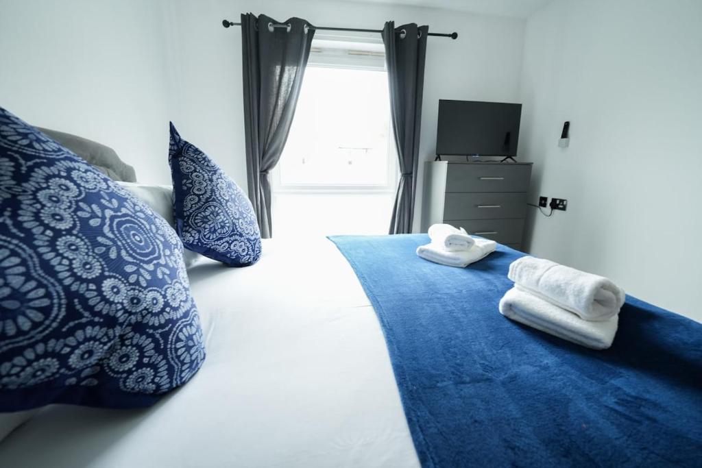a bedroom with a bed with two towels on it at Stylish 1-Bedroom Apartment sleeps 4 in Swansea