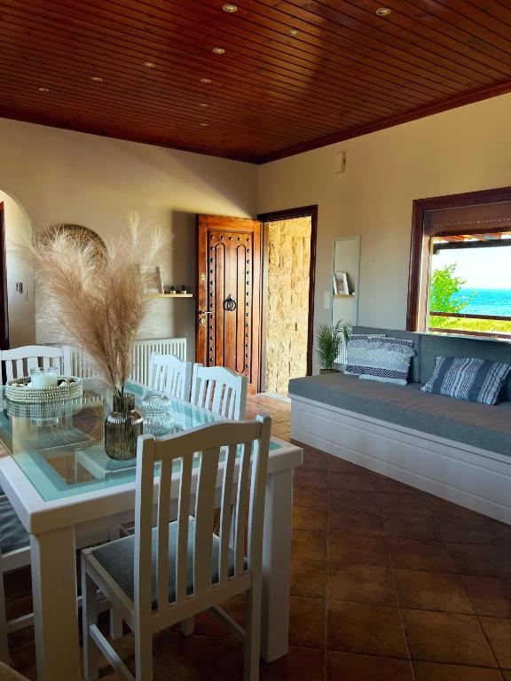 a dining room with a couch and a table and chairs at Anatèlia Beach House in Portianón