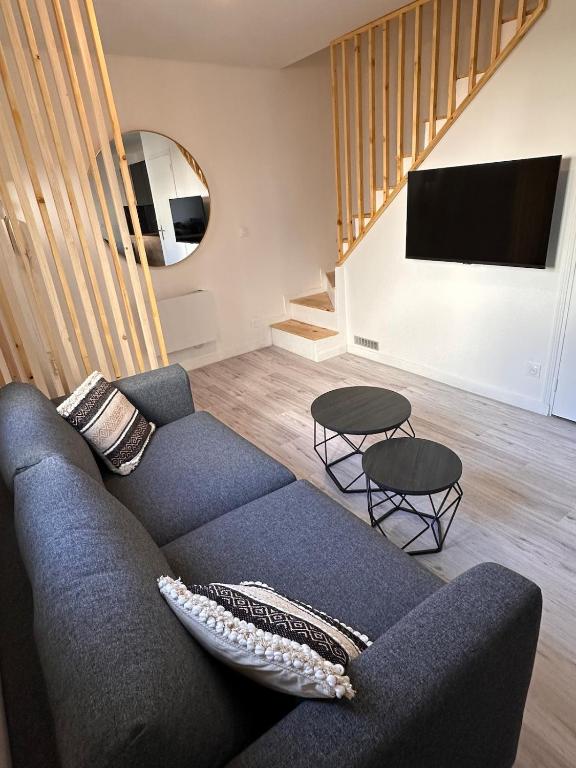 un salon avec un canapé bleu et deux tables dans l'établissement Maisonnette Gambetta, à Amboise