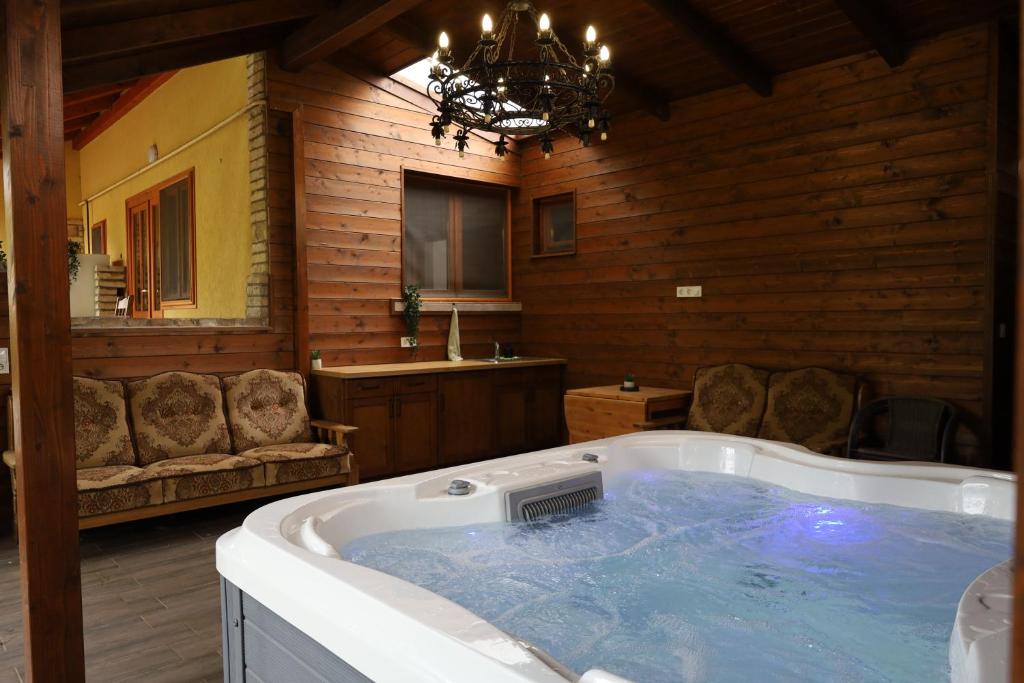 a large bathroom with a hot tub with a chandelier at Halász Vendégház Jakuzzival Tiszakécske in Tiszakécske