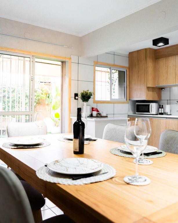 a dining room table with a bottle of wine and glasses at Firmat Apart Premium Estadías confortables para empresas y familias 2 in Firmat