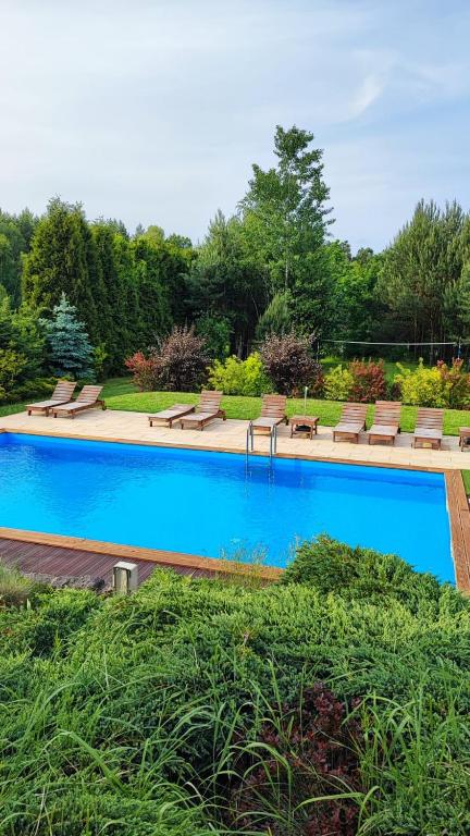 a large swimming pool with benches and ahaps at Szewilla in Szewnia
