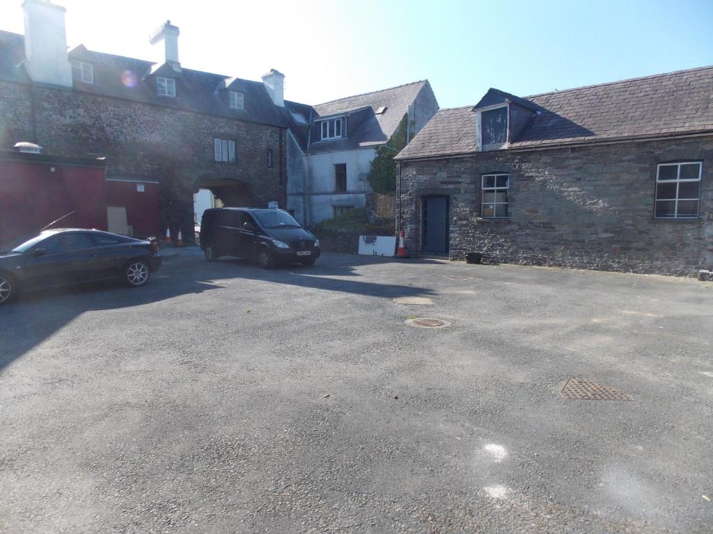 a parking lot with two cars parked in front of a building at The Red Lion in Llangadog