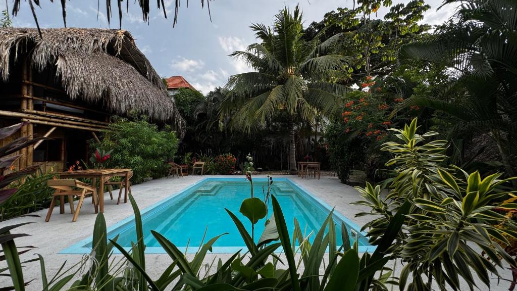 a swimming pool in a resort with a table and chairs at Aguarinwa Hostel in Palomino