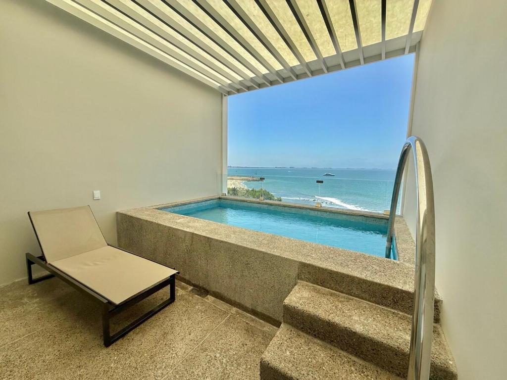 Una habitación con piscina, una silla y una ventana. en Zantamar, Penthouse 605B, en Cruz de Huanacaxtle