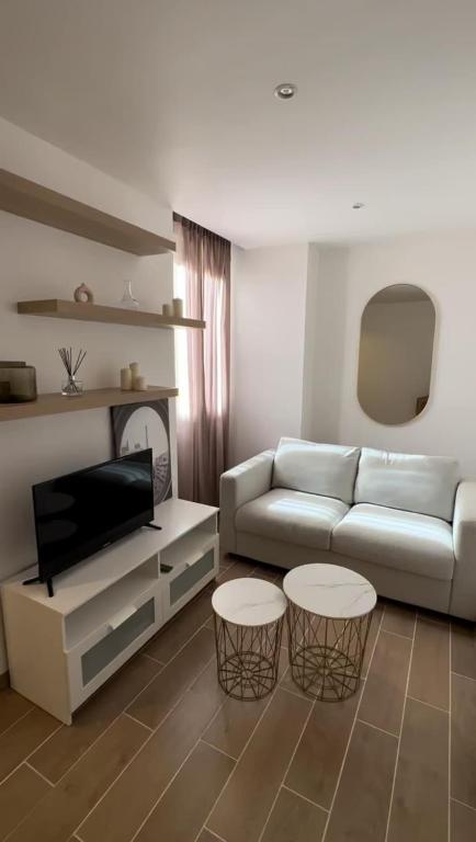 un salon avec un canapé et deux tables dans l'établissement 2 pièces aux porte de Monaco , Plage , Tennis ,GP, à Beausoleil