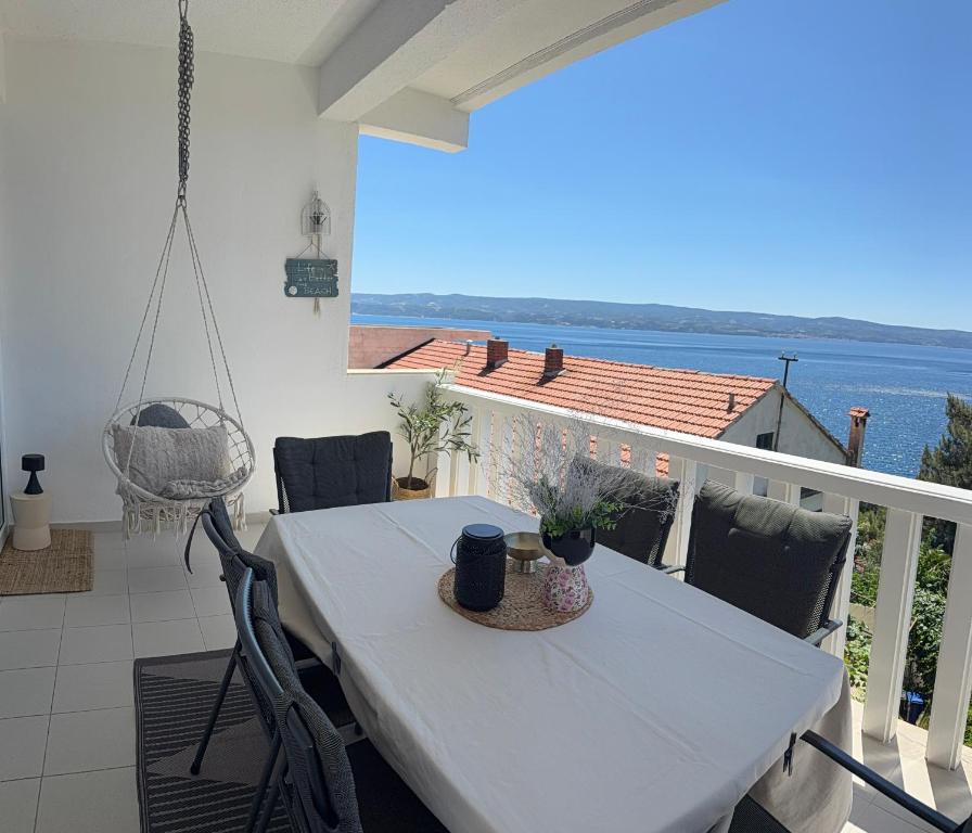 a table and chairs on a balcony with a view of the ocean at Apartments Anamarie in Omiš