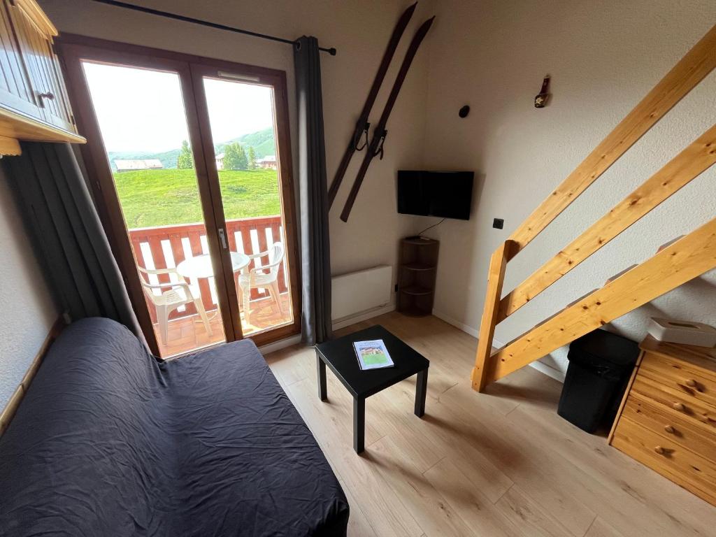 - une chambre avec un lit et un balcon avec une porte coulissante en verre dans l'établissement Duplex 4 couchages La Toussuire, à La Toussuire
