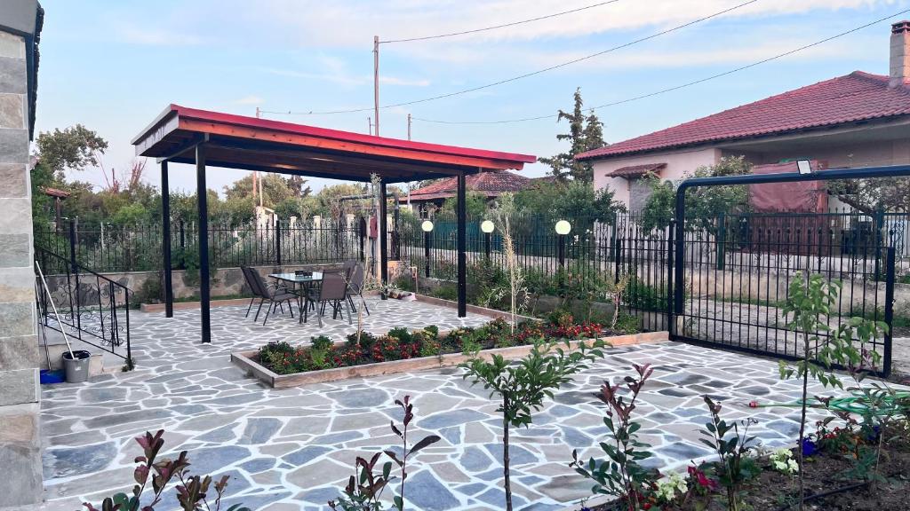 a patio with a pavilion with a table and chairs at Beach Getaway in Nea Irakleia