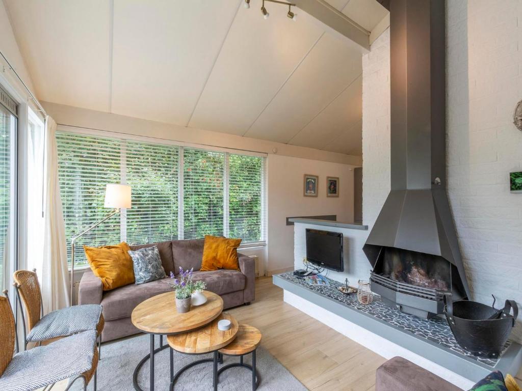 ein Wohnzimmer mit Couch und Kamin in der Unterkunft Family Home by the Dunes in Sint Maartensvlotbrug