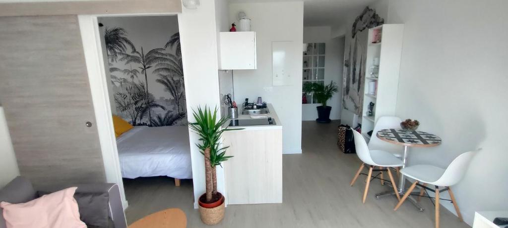 a kitchen and a bedroom with a bed and a table at Appartement Le doux Viking, balcon & parking privé proche Zénith Caen in Caen