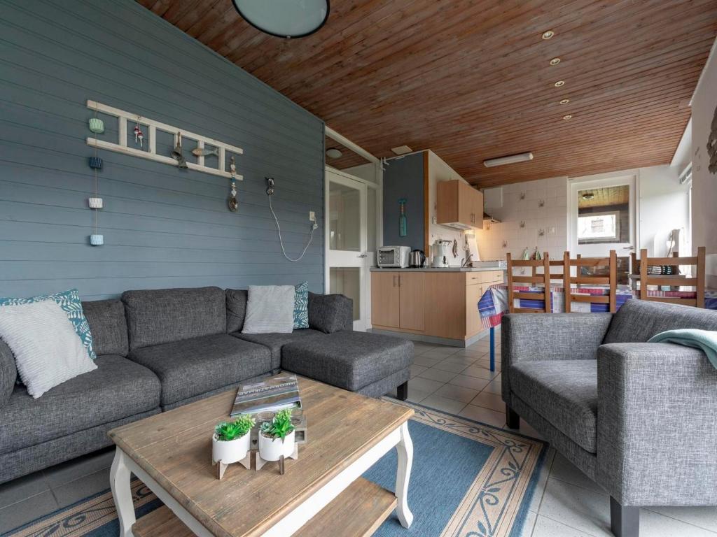 a living room with a couch and a table at Holiday Home Sint Maartenszee near Beach in Sint Maartenszee