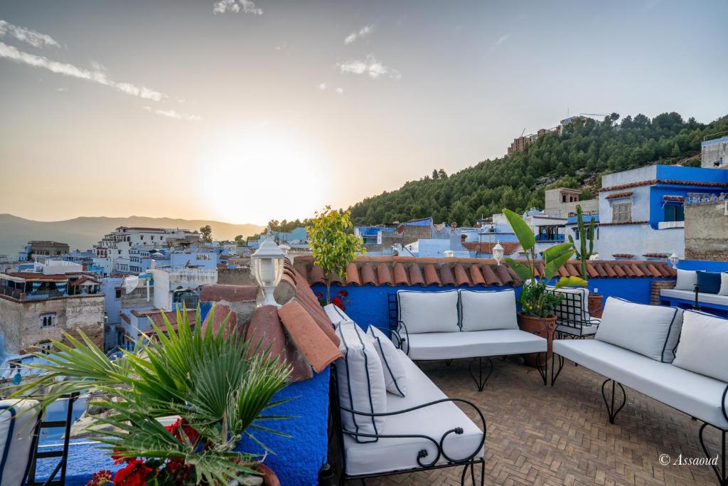 a balcony with couches and a view of the city at Dar Bleumain in Chefchaouen