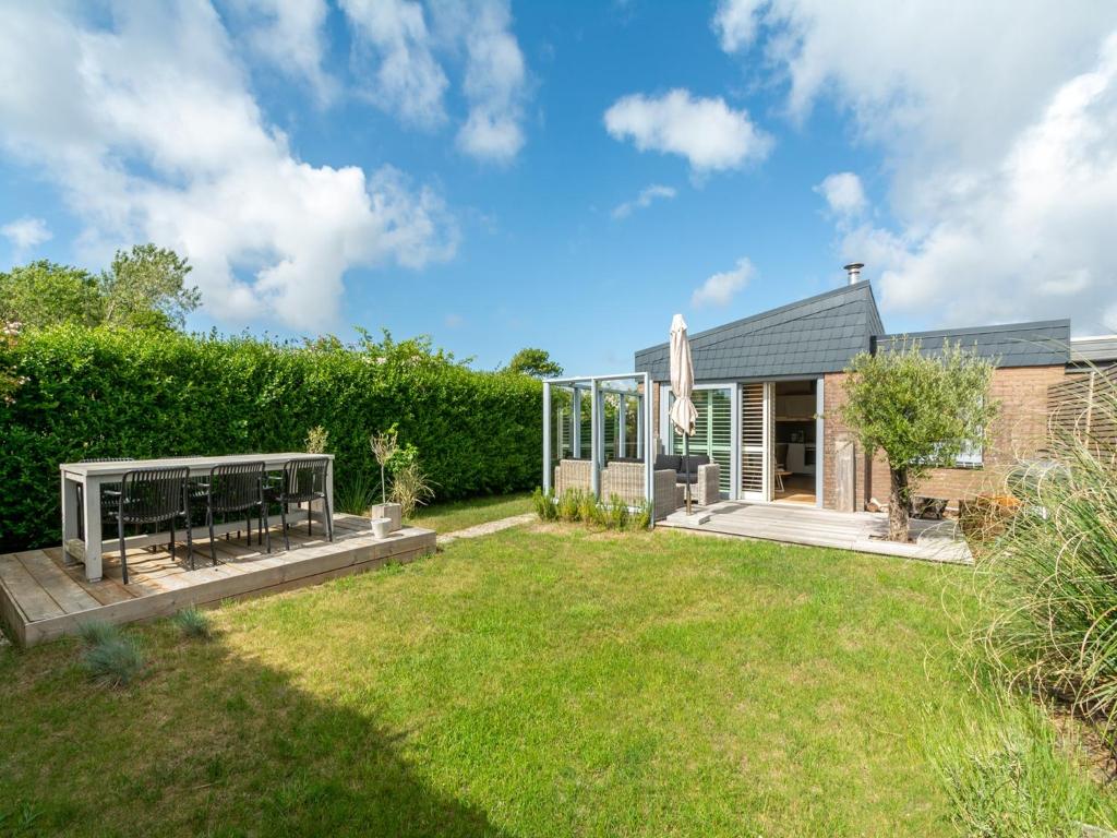 a house with a garden and a patio at Bungalow in Callantsoog near the Beach in Callantsoog