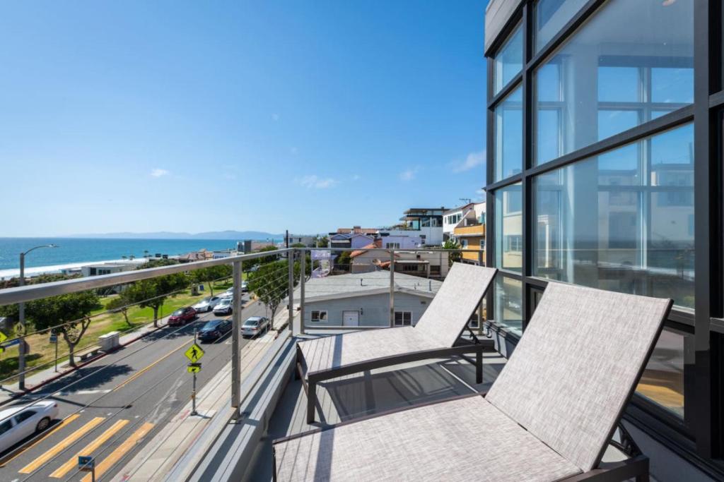 two chairs sitting on the balcony of a building at Stunning Panoramic Ocean Views Penthouse Hot Tub in Manhattan Beach