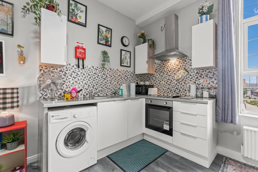 een witte keuken met een wasmachine en droger bij 15 Stylish Digbeth private Studio Apt City Centre in Birmingham