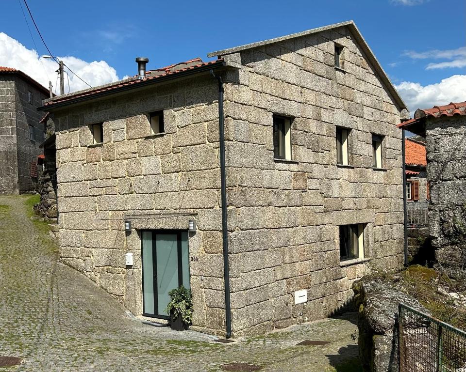 a stone building with a door on the side of it at Casa da Fonte, Monte in Terras de Bouro