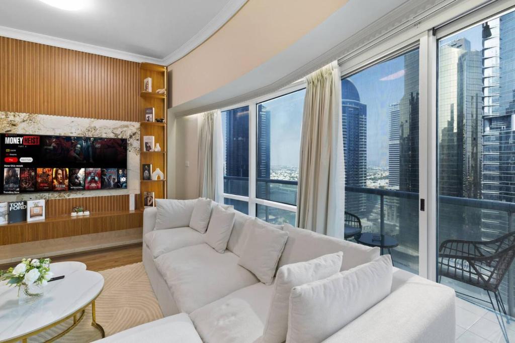 a living room with a white couch and a large window at Elegant Haven and Spacious 2BR in Lake Terrace in Dubai