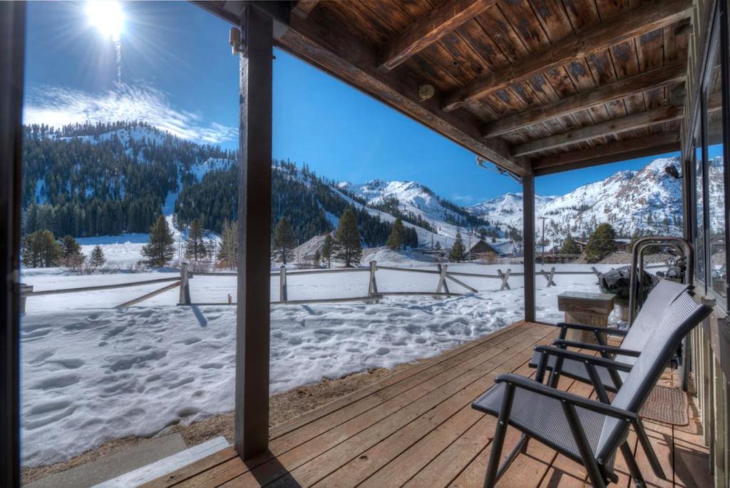 Eine Terrasse mit einem Stuhl und Blick auf schneebedeckte Berge in der Unterkunft Serene Condo by Palisades Base and Golf Course in Olympic Valley